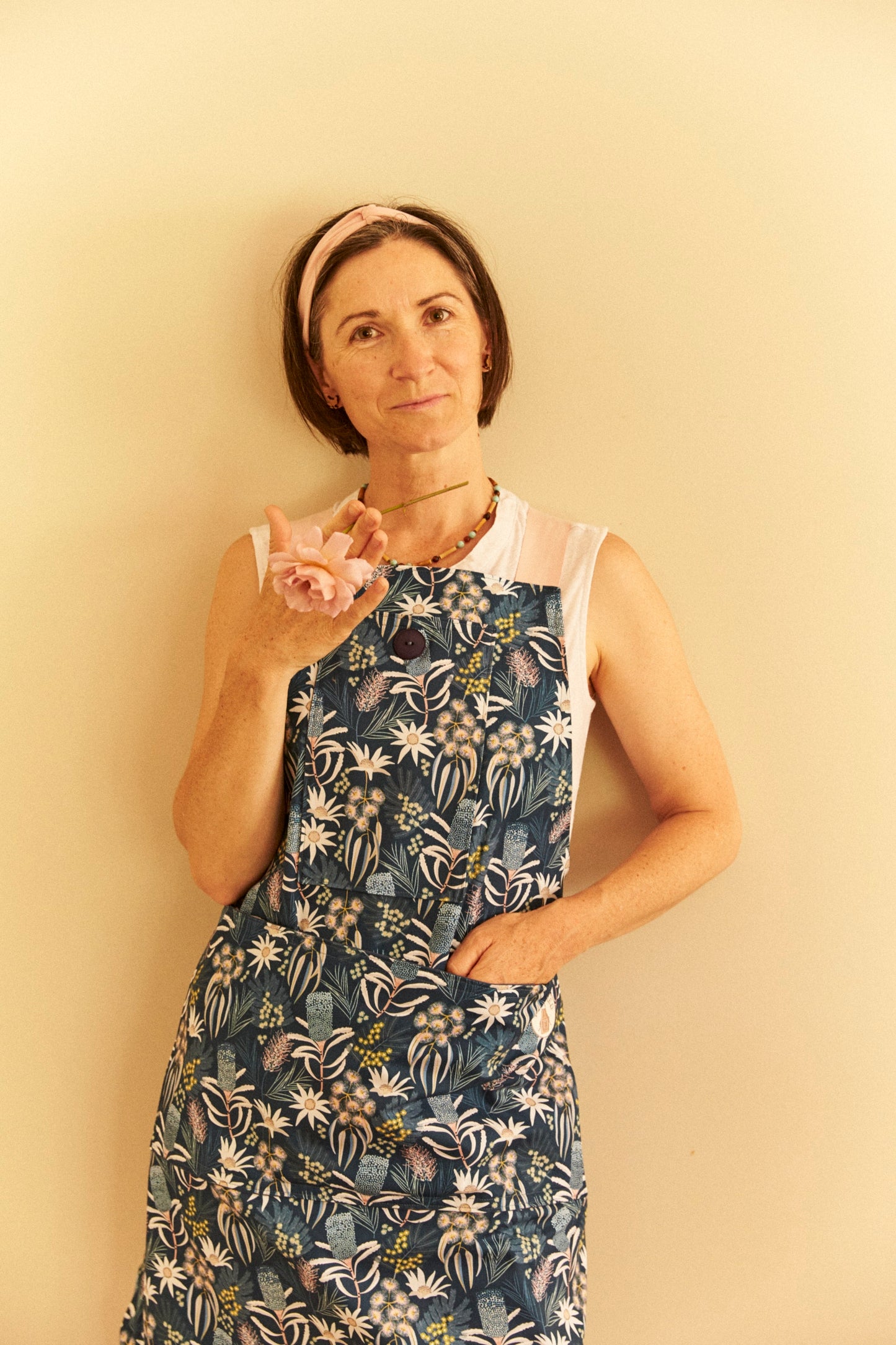 Woman wearing a floral dress against a plain background