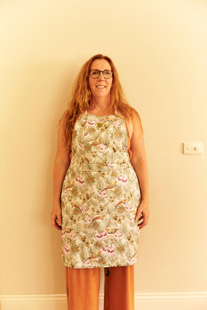 Woman wearing a floral dress against a plain wall.